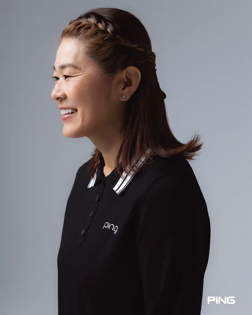 黒の襟付きニットを着用し笑顔を見せる澤穂希さん